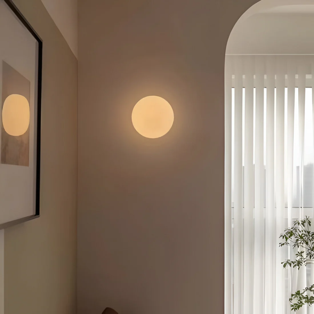 Minimalist glass bathroom wall light with a spherical shade