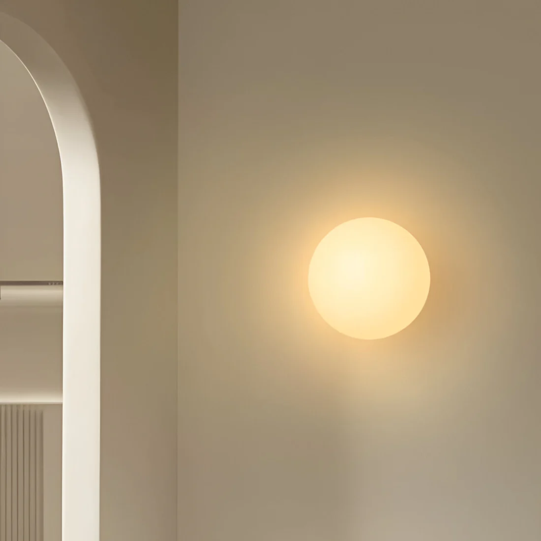 Minimalist glass bathroom wall light with a spherical shade