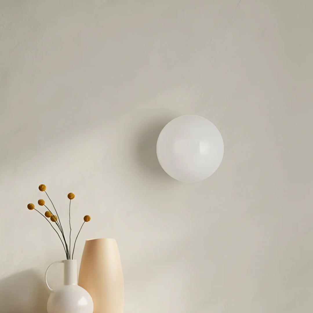 Minimalist glass bathroom wall light with a spherical shade